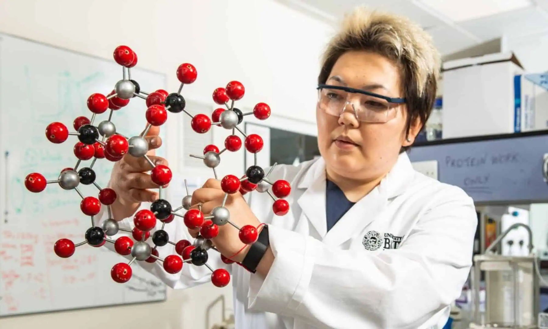 Scientist wearing protective eyewear and a face mask illustrating the growing testing and analytical workload faced by labs