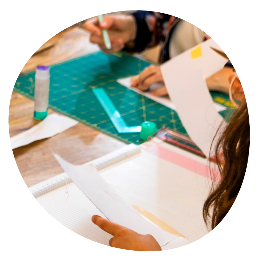 Email Image: People crafting at a table using a cutting mat, glue and paper cut outs.