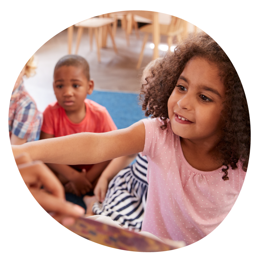 Image: Young children cluster around an adult holding an open picture book.