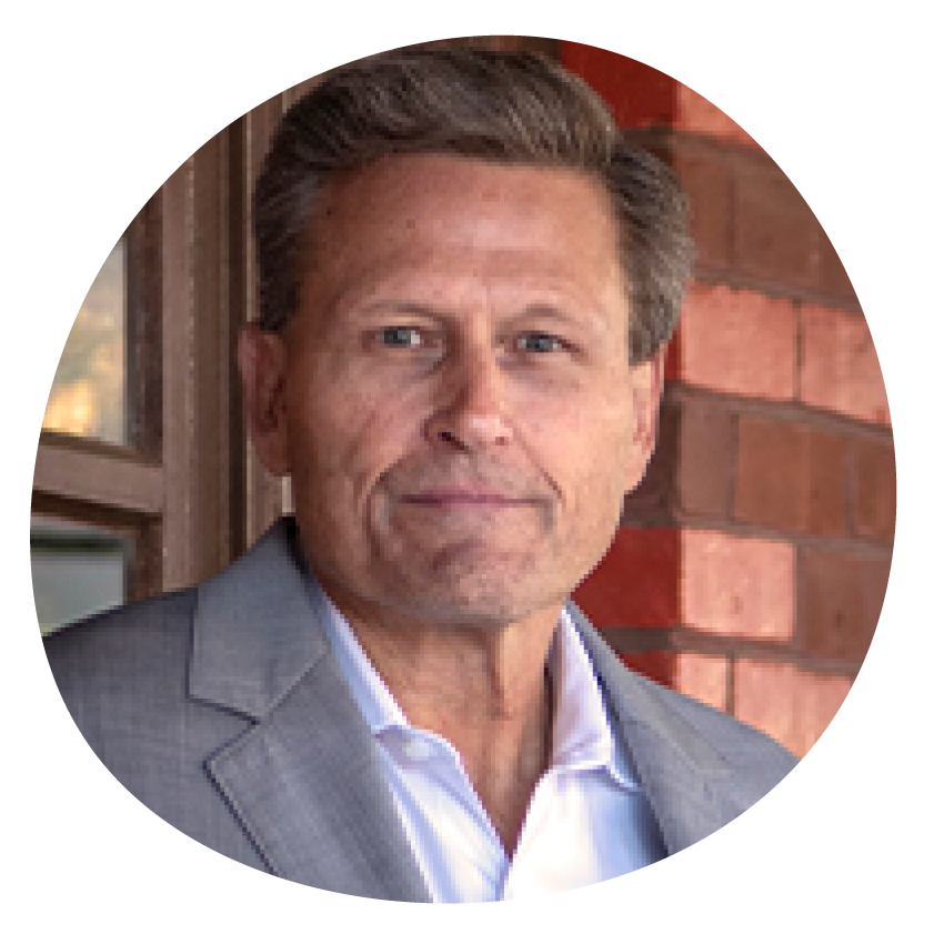 Author David Baldacci stands in front of a red brick wall