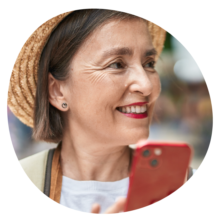 A smiling person wearing a sun hat and holding a smartphone.