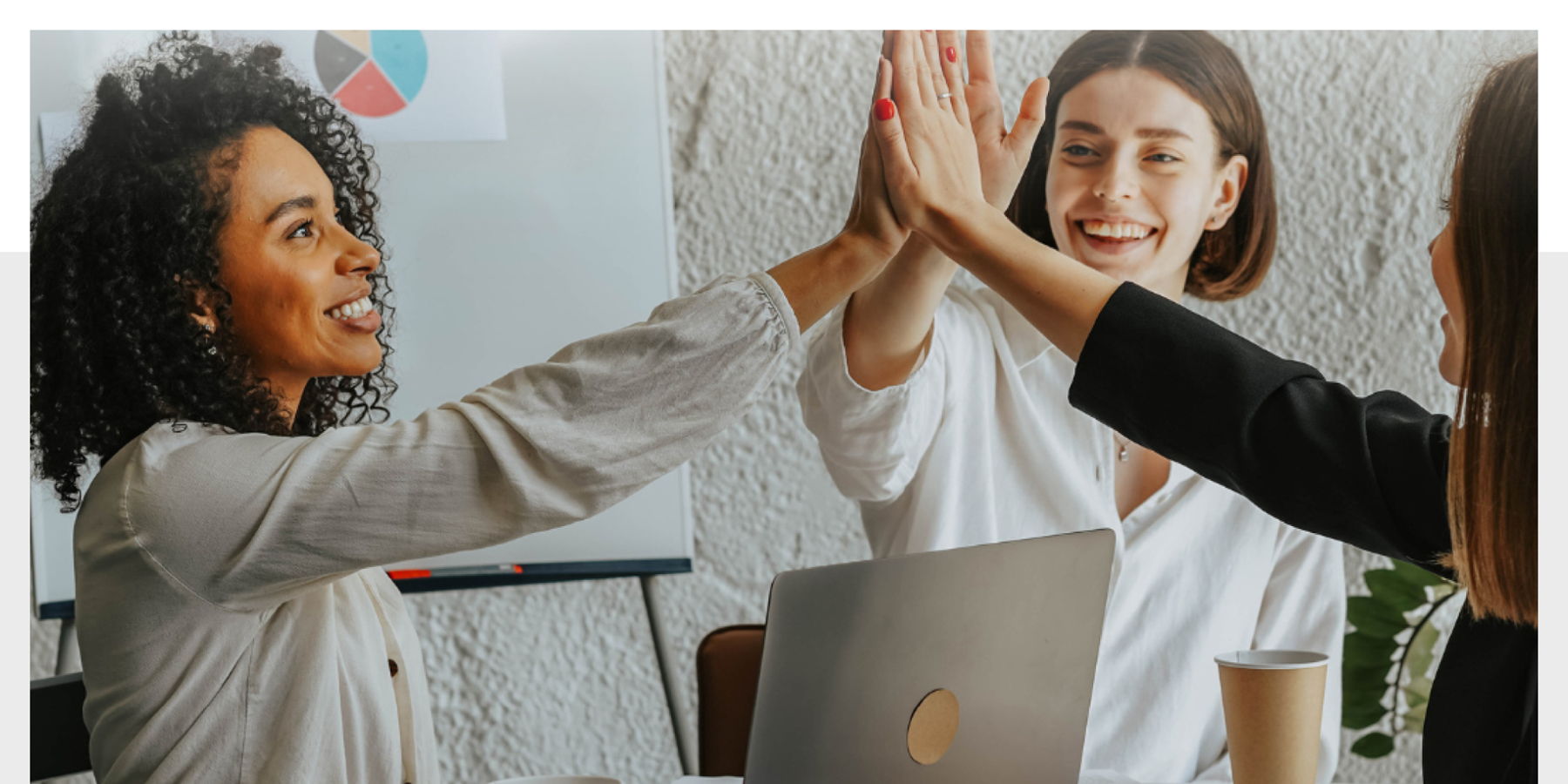 Email Image: Three smiling women high fiving over an open laptop.