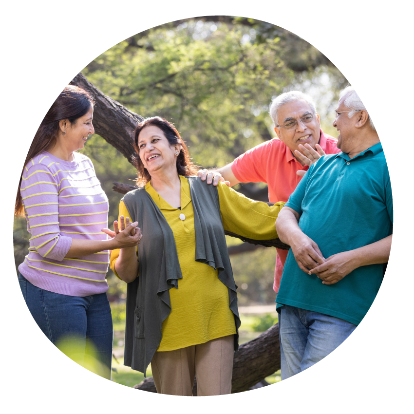 Image: Four adults in friendly conversation in a garden.
