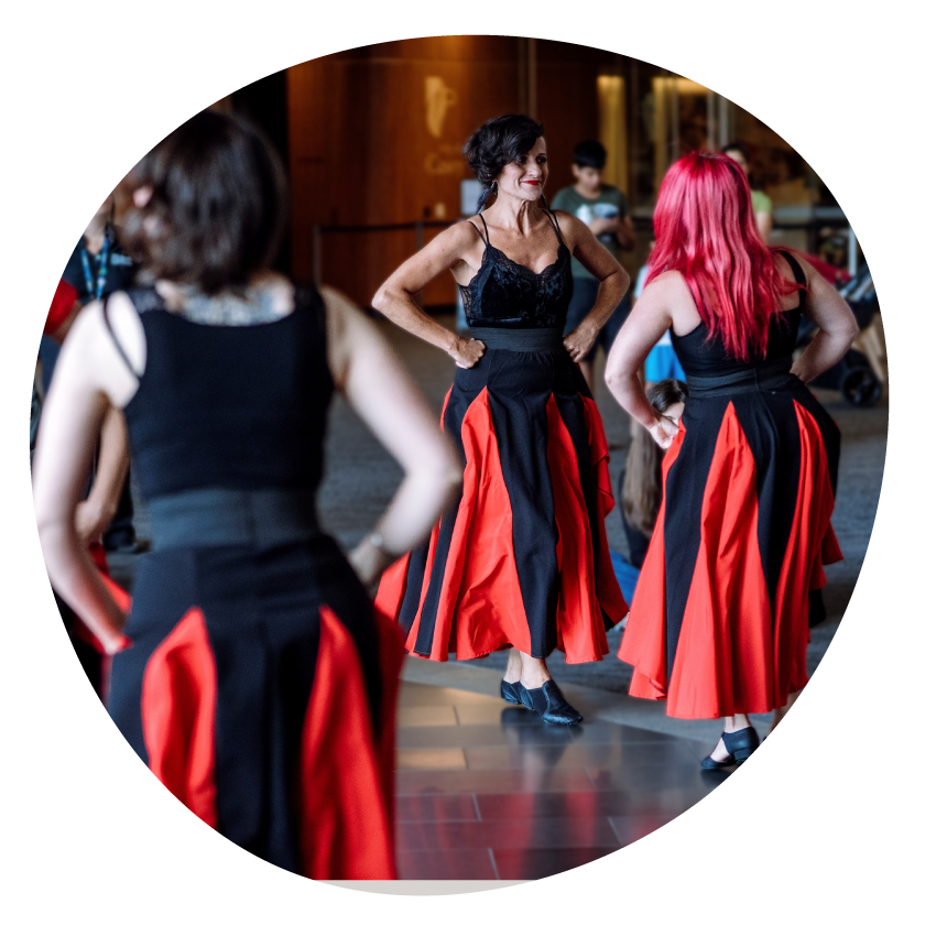 Dancers from the Melbourne School of Tarantella perform in black and red costumes.