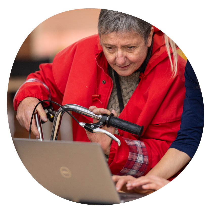 Image: A library staff member and customer look at a laptop together.