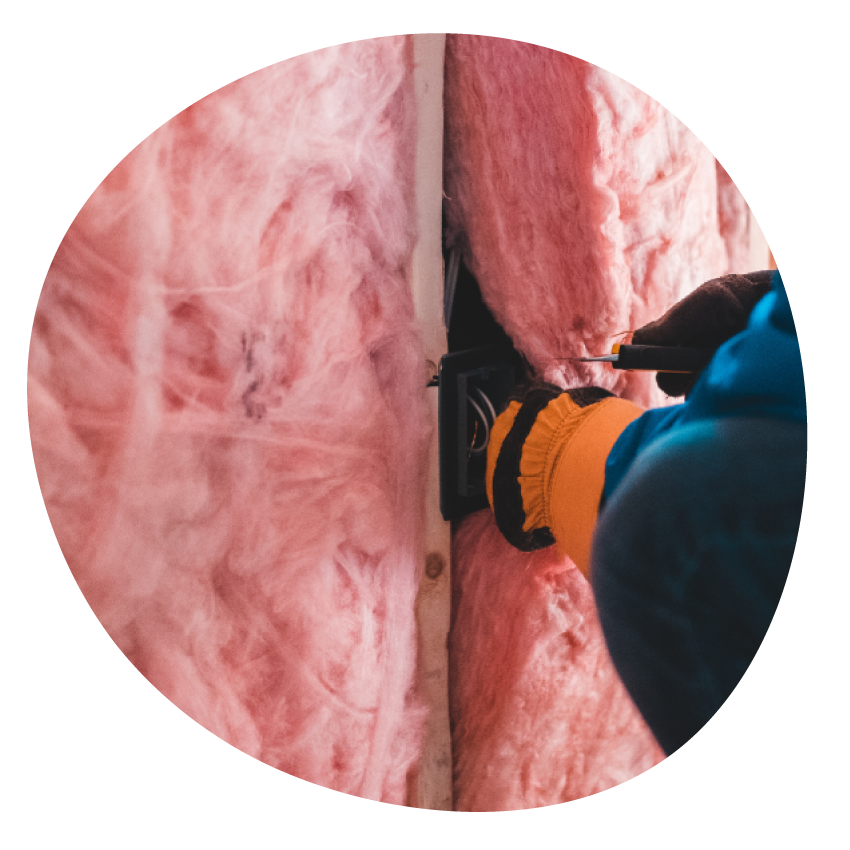 Image: A person installing wall insulation.