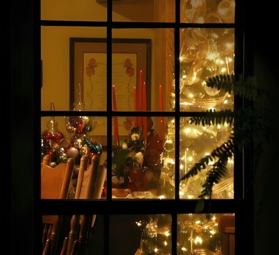 A decorated Christmas tree is seen through a window
