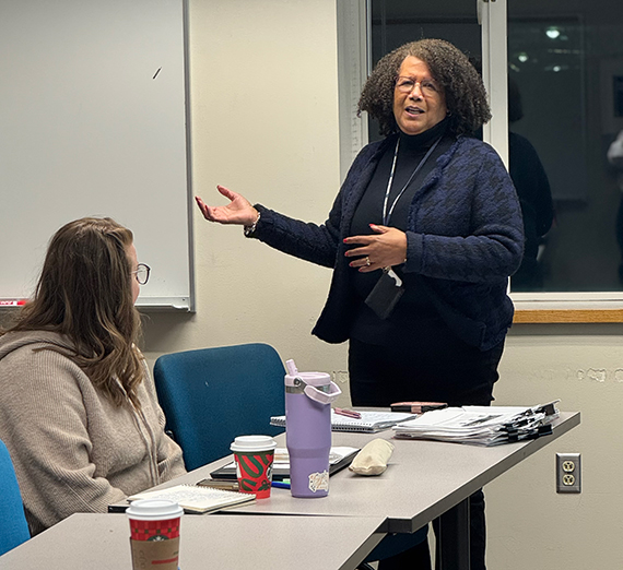 A woman stands in front of a class