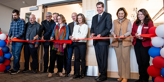Professor John Collet, Kyle Sweeney, Michael Hanrahan, Natalie Keller, and Madylin Campbell pose for a photo with the Super Bowl LX logo