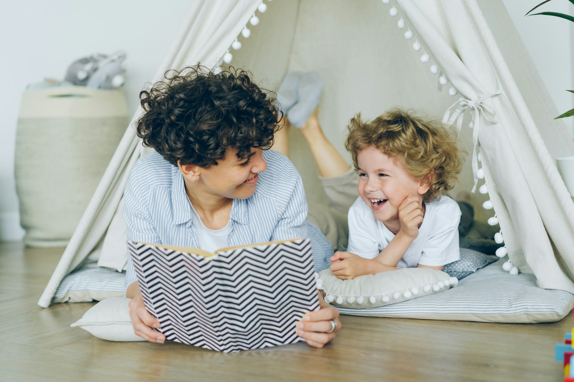 Mother and child reading happily in a tent