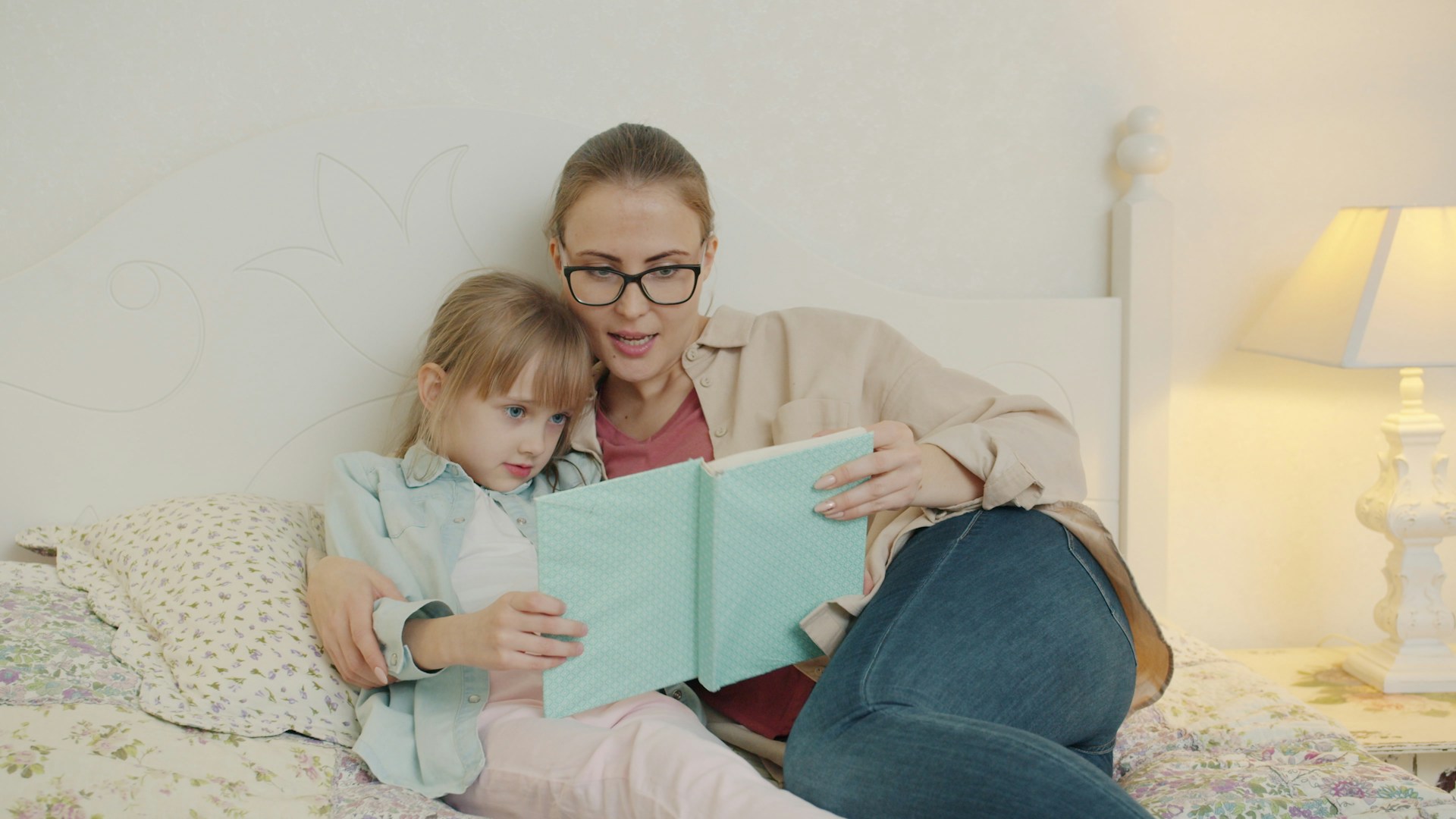 Mother and daughter snuggled up together reading
