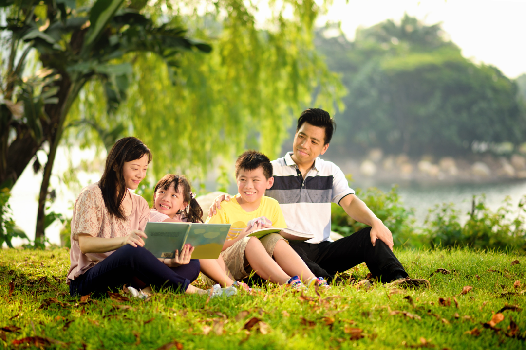 Family reading together outdoors