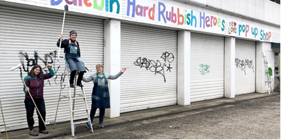 three people on a ladder next to the hard rubbish heroes pop up shop
