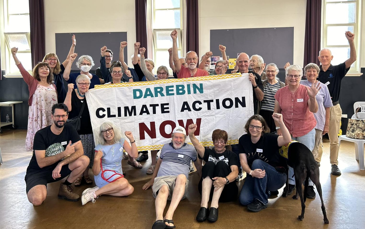 Darebin Climate Action Now members standing with a large banner that says Darebin Climate Action Now