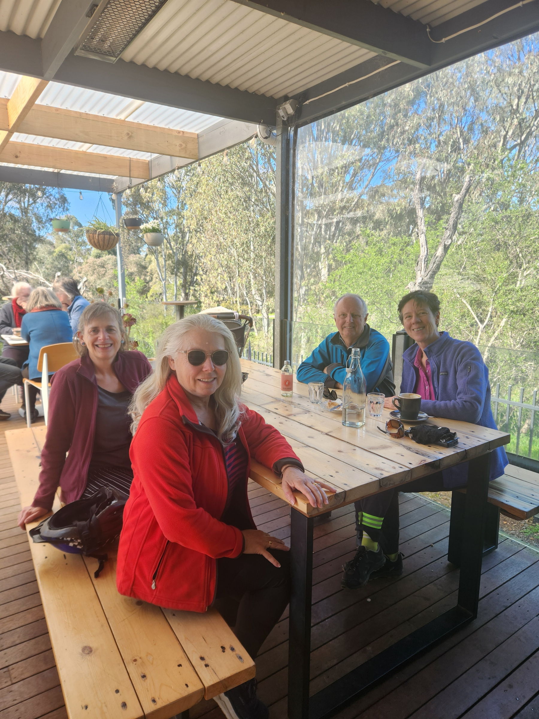 Four people sitting around a table having a break from riding