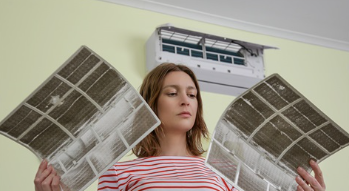 person looking at their split system filters to clean them