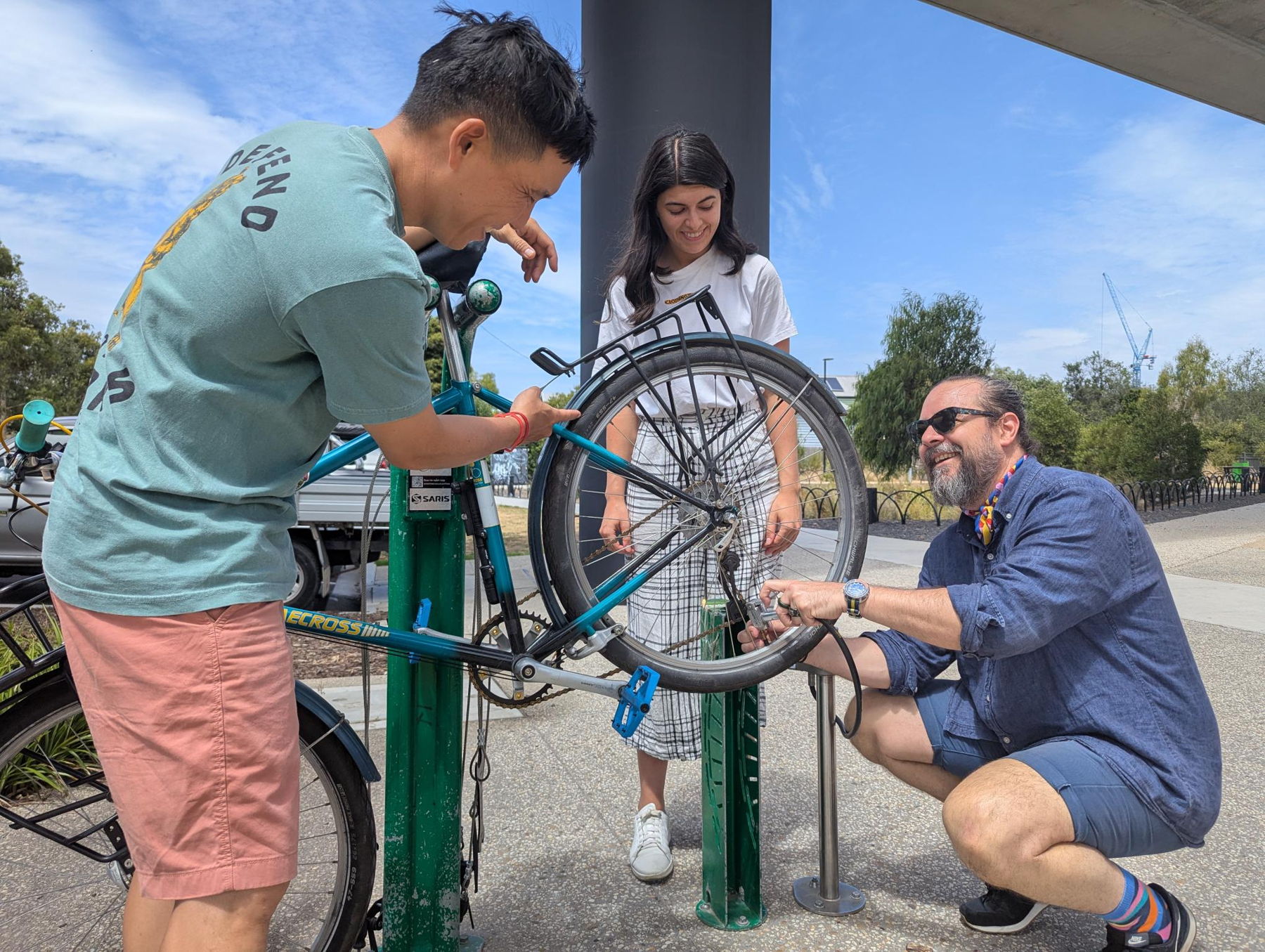 Group of people working together on fixing a bike on a stand