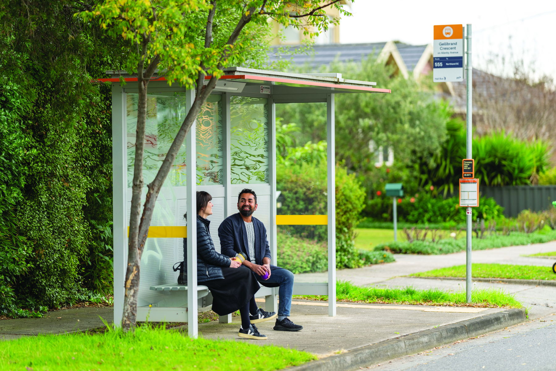 Two people waiting at a bus stop
