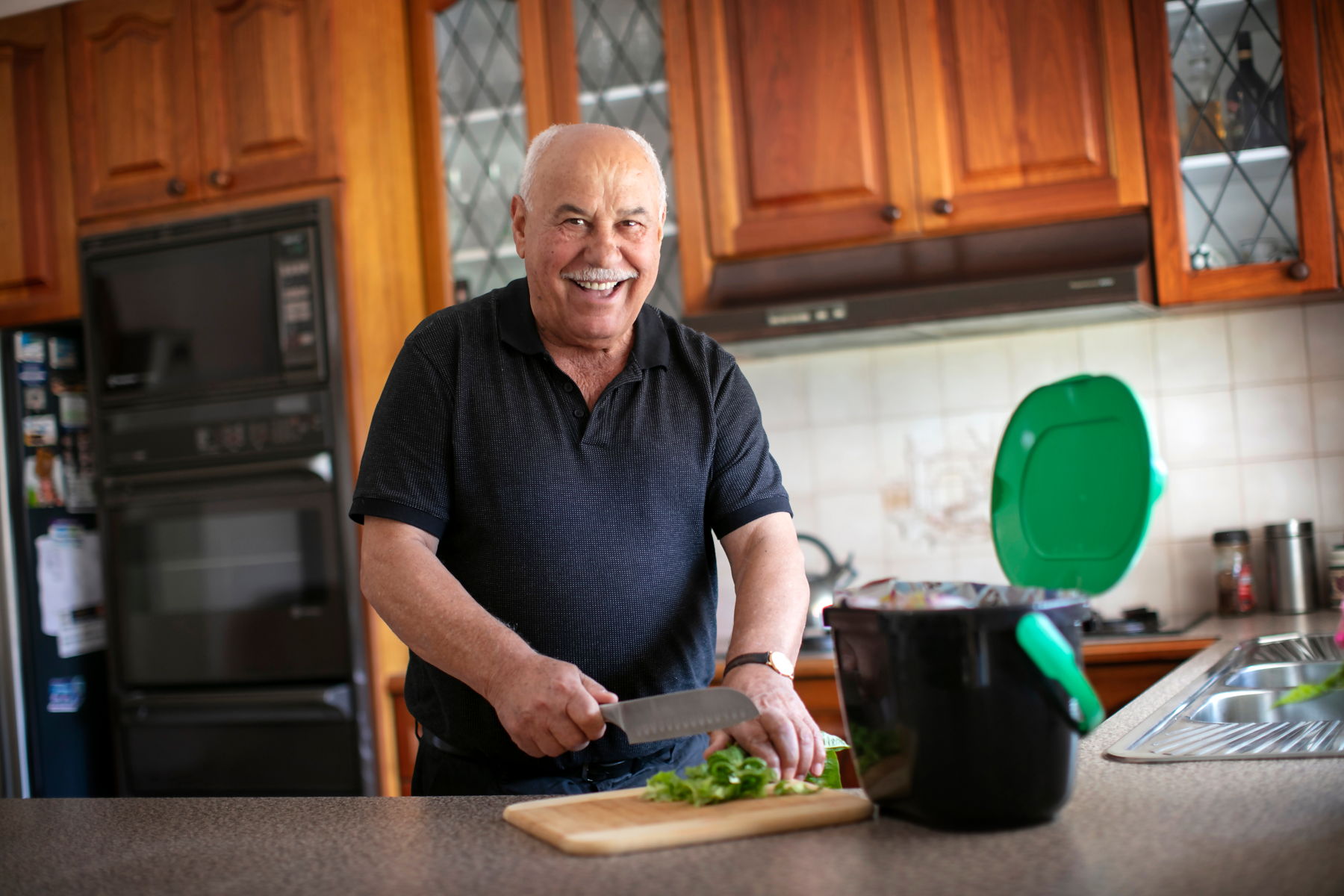 Darebin resident Blaje using his kitchen caddies to collect green waste