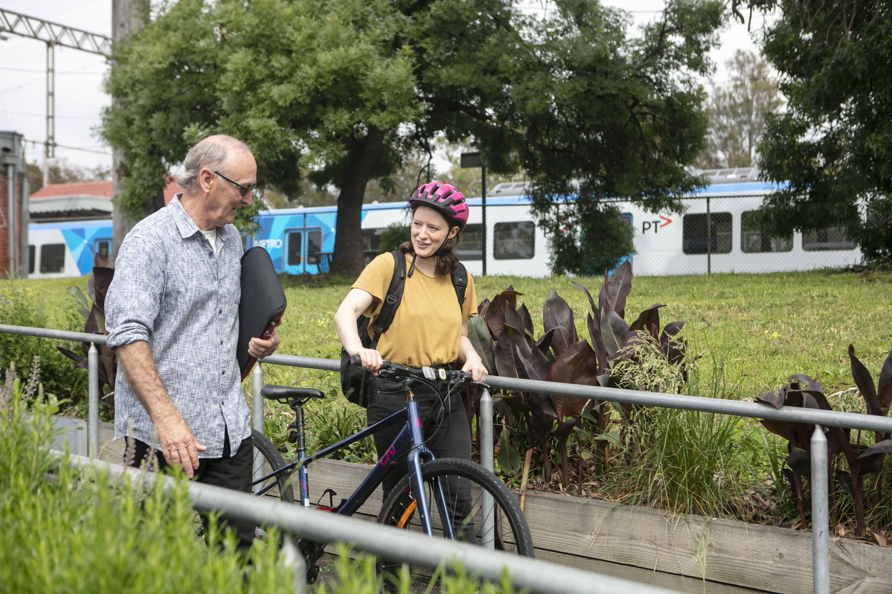  Man and woman walking a bicycle down a ramp and having a chat