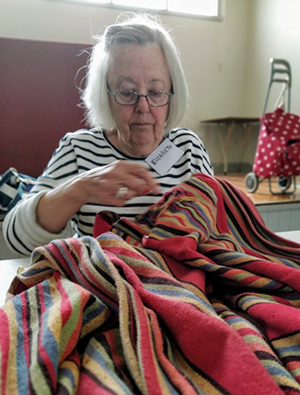 Image of a volunteer mender fixing an item of clothing