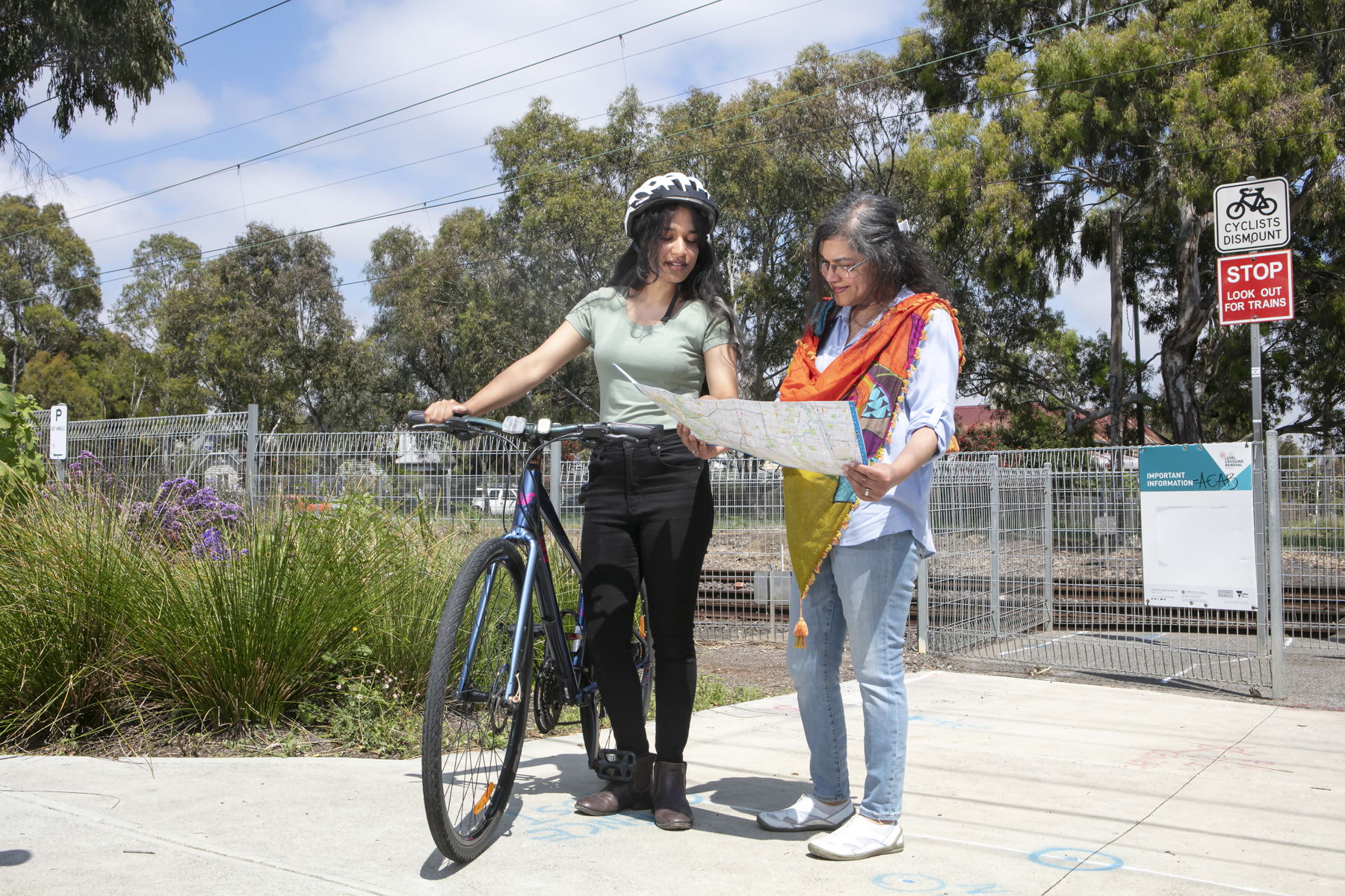 Two women, one holding a bike, reading a Darebin TravelSmart Map