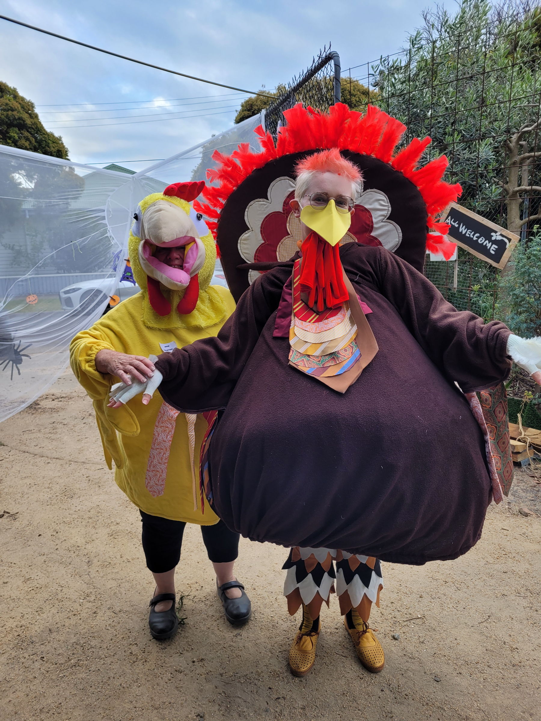 Photo of two people dressed in chicken costumes standing in Sylvester Hive Community Garden