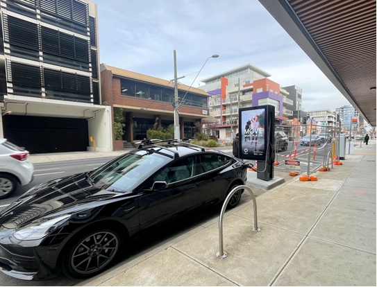Black car being charged at a public EV charger in Preston