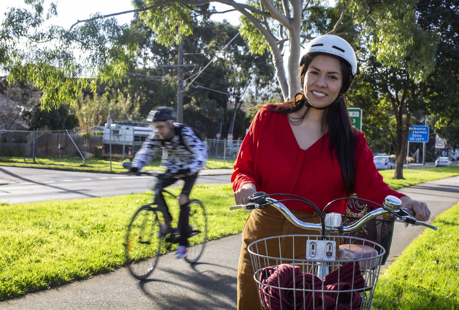 Two people stand by their bikes smiling at each other in a street