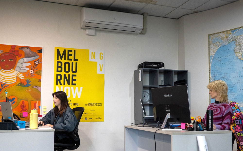 Two women working in an office with a split system on the wall
